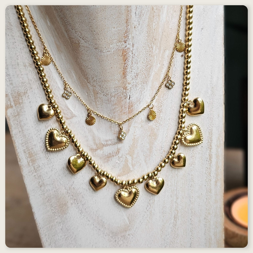 Goudkleurige stainless steel kralenketting met meerdere kleine hartbedels