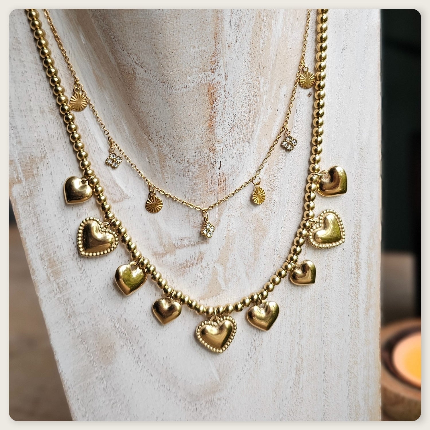 Goudkleurige stainless steel kralenketting met meerdere kleine hartbedels