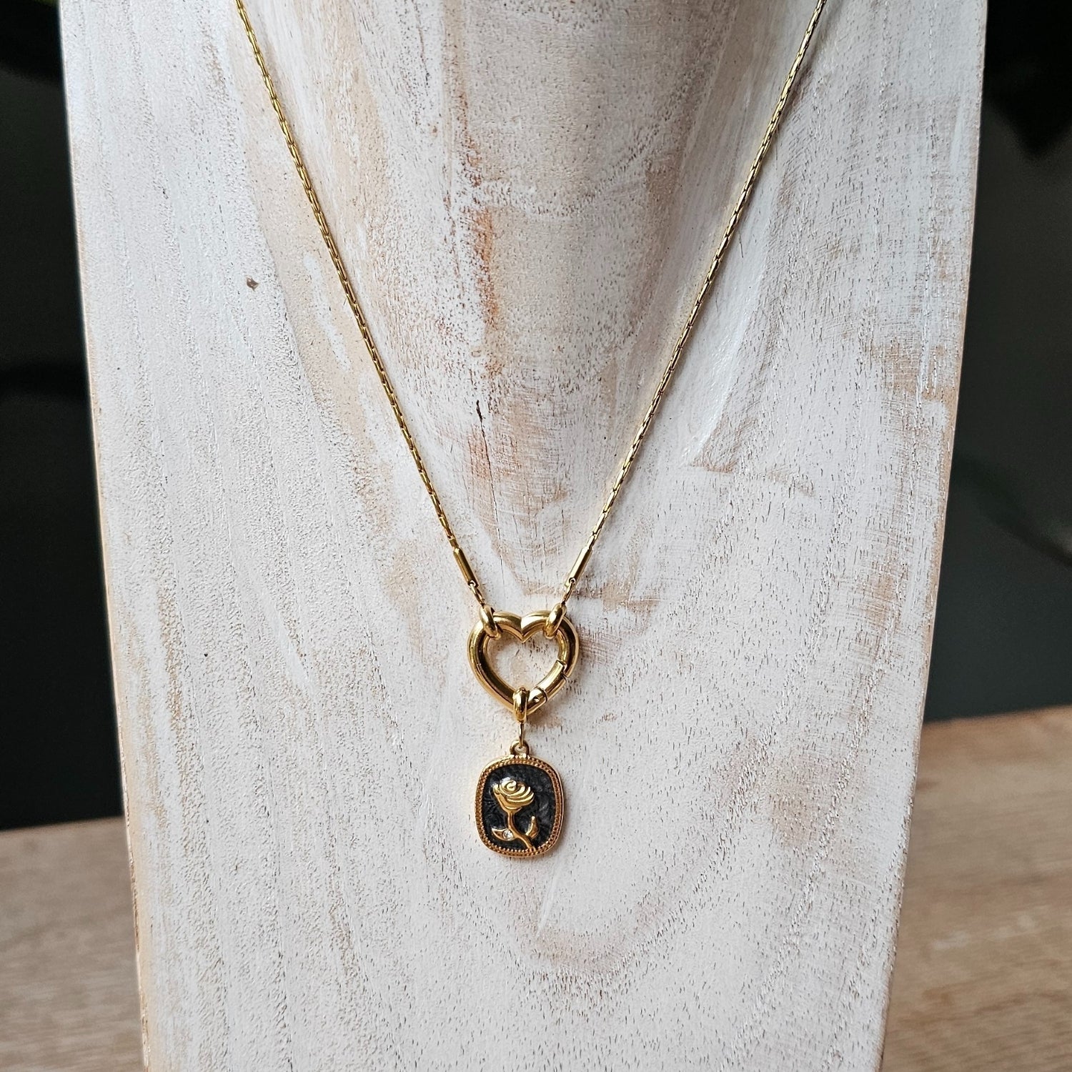 Seyso goudkleurige bedel met roos in reliëf op een zwarte achtergrond, verfijnd design met subtiel steentje en een elegant oogje voor persoonlijke sieraden