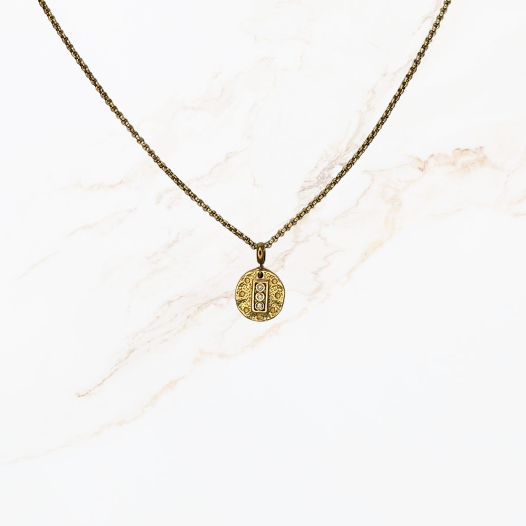 Goudkleurige ketting voor het zelf samenstellen van een ketting met verwisselbare bedels op lichte marmer achtergrond.