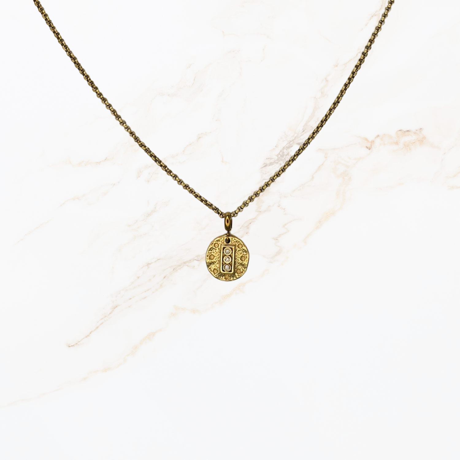 Goudkleurige ketting voor het zelf samenstellen van een ketting met verwisselbare bedels op lichte marmer achtergrond.