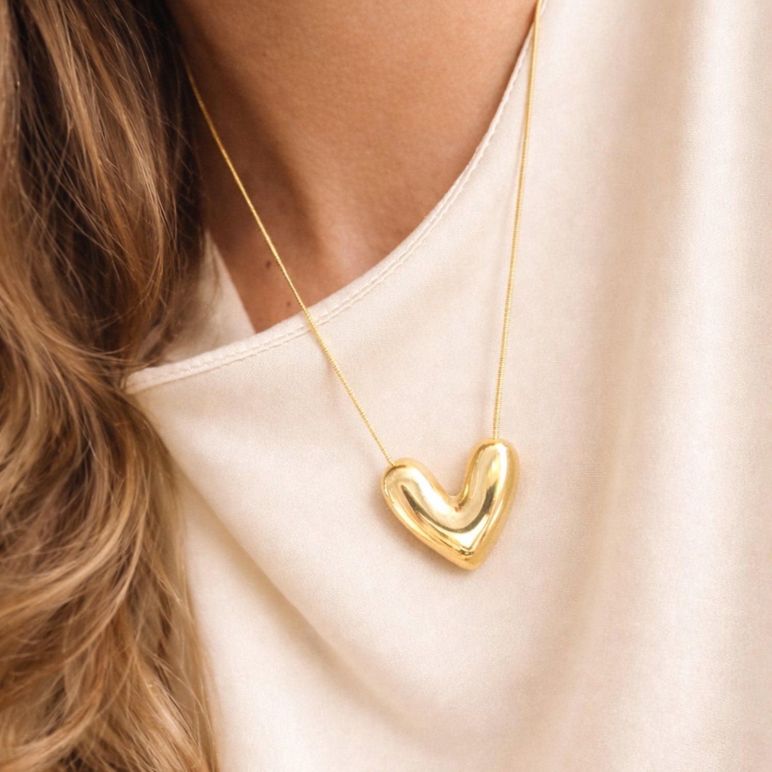 Goudkleurige stainless steel slangketting van 45 cm plus 5 cm met volle hartvormige hanger