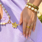 Elastische goudkleurige bangle met steentjes en structuur
