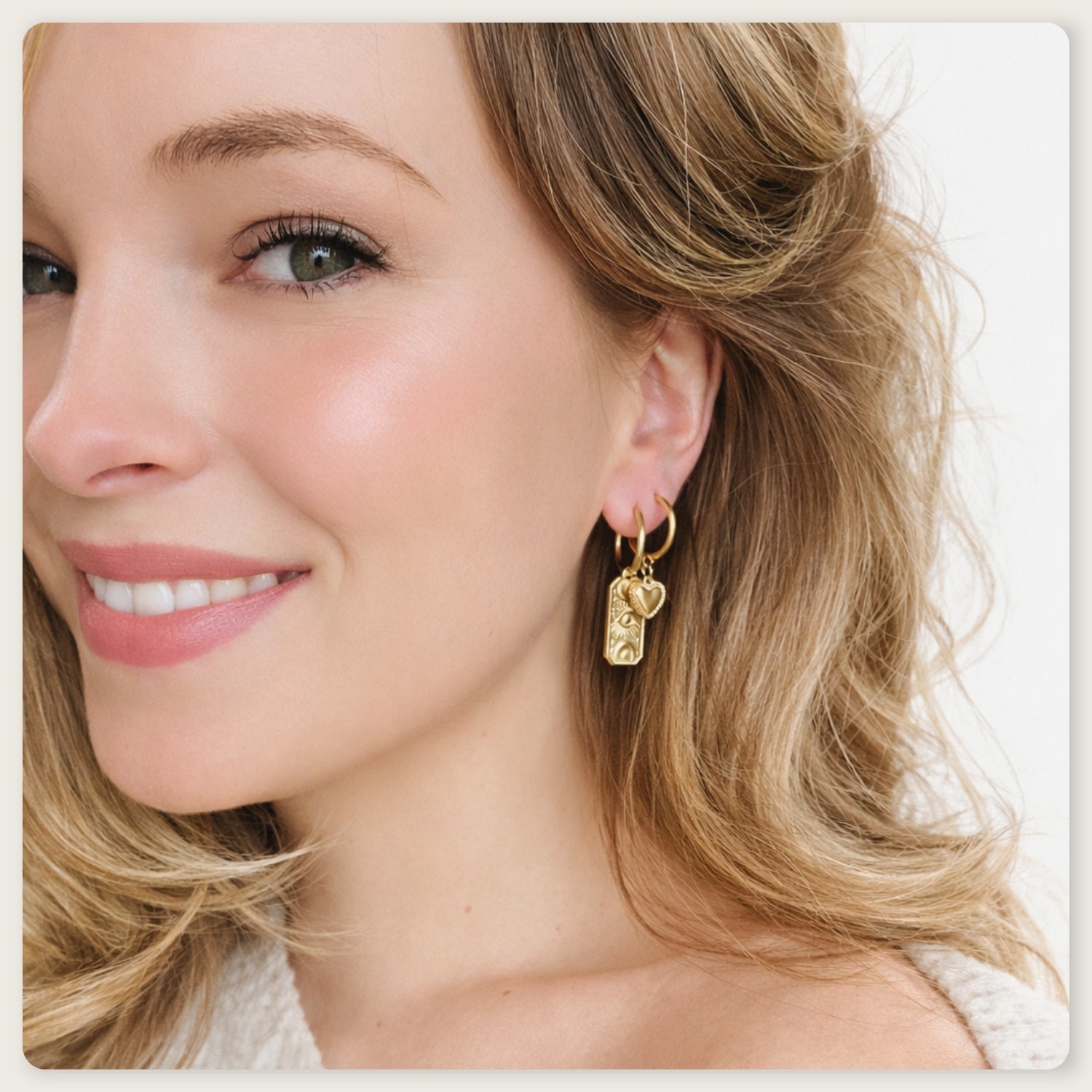Seyso goudkleurige ring oorbellen met klein hartvormig hangertje op lichte marmerlook achtergrond