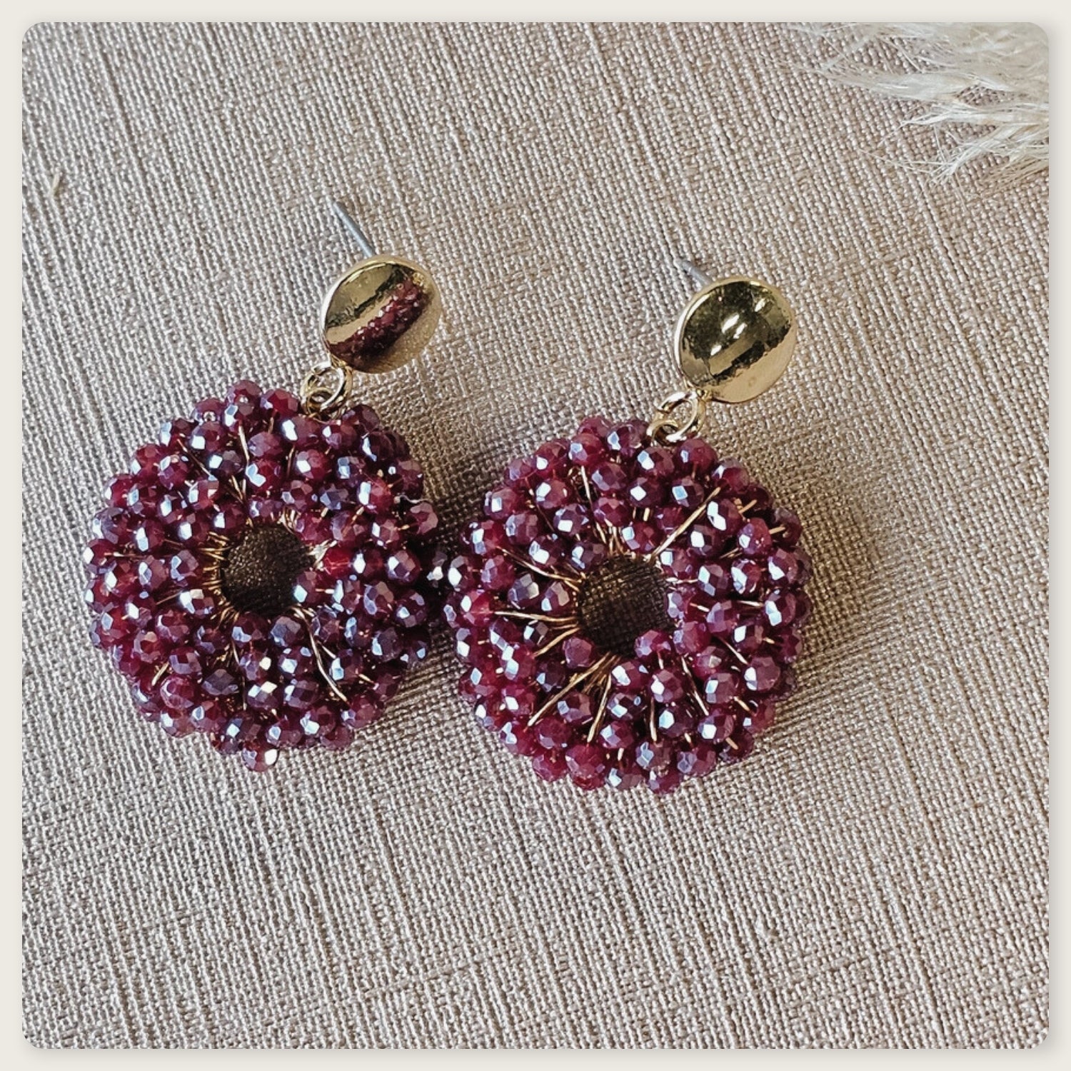 Bordeau rood paarse statement oorbellen met ronde vorm, handgeregen kralen en goudkleurige details