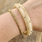 Seyso crème statement bangle voor dames met ronde goudkleurige studs
