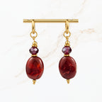 Elegante bordeaux rode oorbellen met glanzende ovale hangers, paarse kristallen en goudkleurige details. Trendy dames sieraden van Seyso.