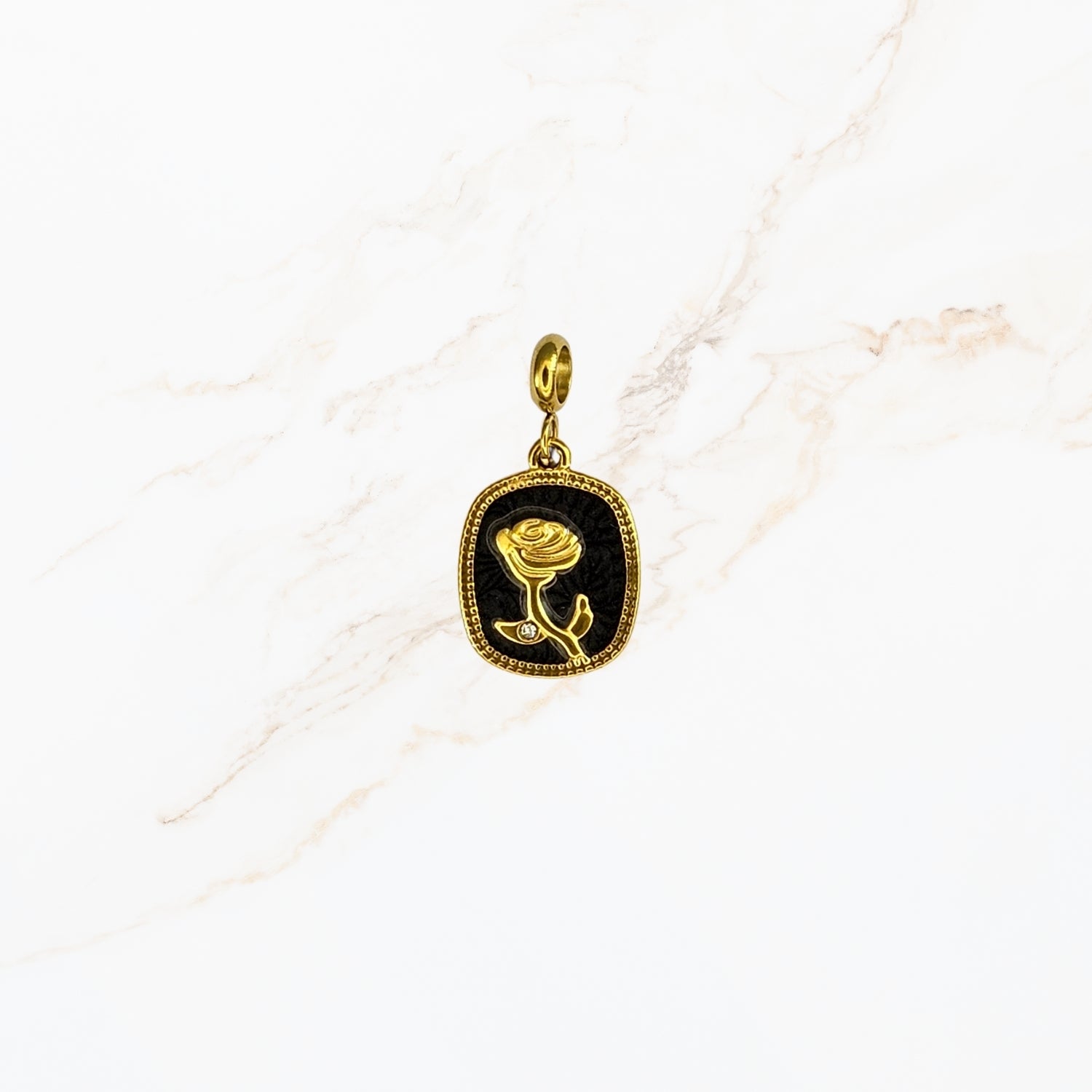 Seyso goudkleurige bedel met roos in reliëf op een zwarte achtergrond, verfijnd design met subtiel steentje en een elegant oogje voor persoonlijke sieraden