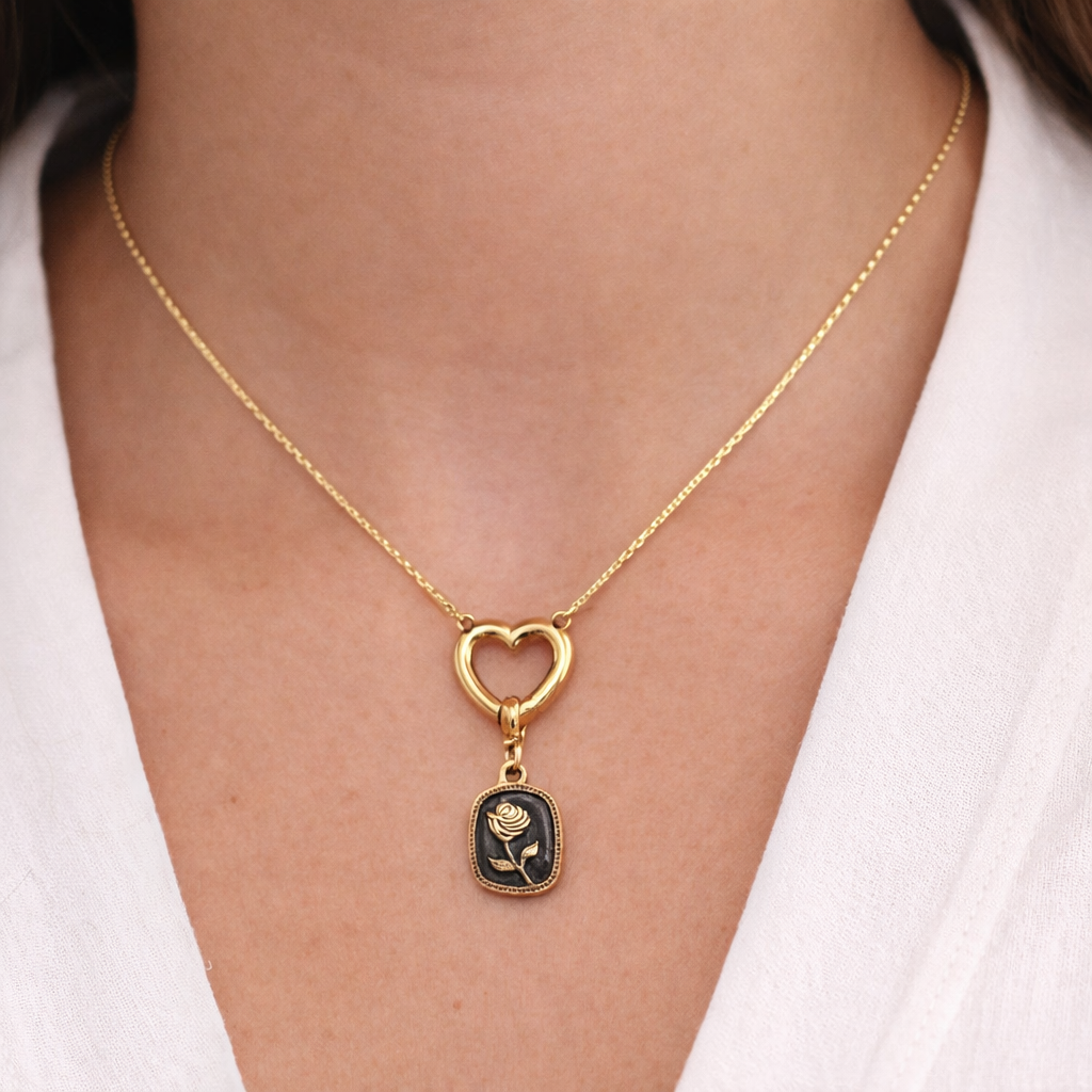 Seyso goudkleurige bedel met roos in reliëf op een zwarte achtergrond, verfijnd design met subtiel steentje en een elegant oogje voor persoonlijke sieraden