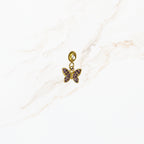 Seyso goudkleurige vlinder bedel met paarse steentjes, fijn vlinderdetail en RVS oogje voor persoonlijke sieraden