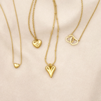 Goudkleurige stainless steel schakelketting met hartvormige hanger en bloemdetail