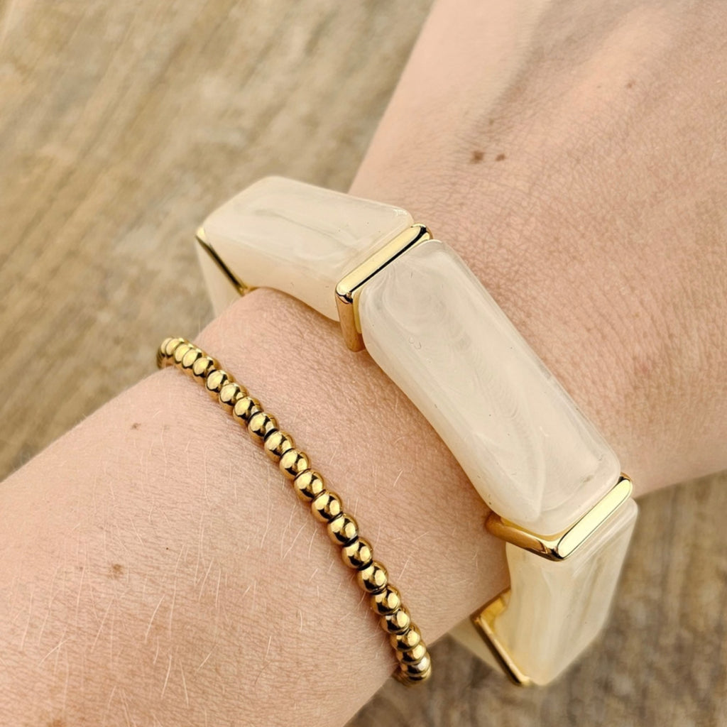 Beige dames armband met brede crème elementen en elegante gouden accenten