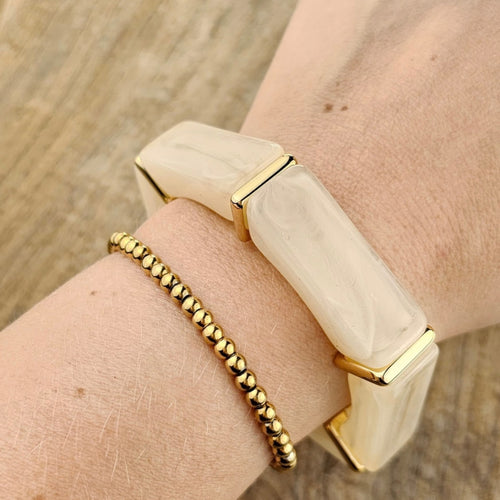 Beige dames armband met brede crème elementen en elegante gouden accenten
