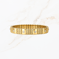 Elastische goudkleurige bangle met steentjes en structuur