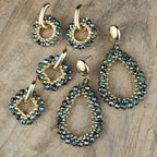 Verschillende groene statement oorbellen met ronde en druppelvormige hangers, glinsterende groenblauwe kralen en goudkleurige details.