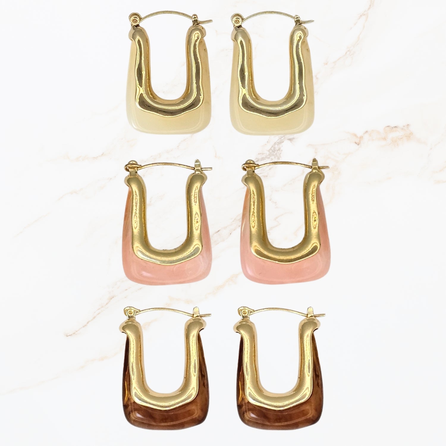 Seyso gouden U vorm oorbellen met marmerlook in wit roze en bruin. Statement oorbellen met glanzend design en elegante uitstraling.