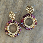 Verschillende ronde en druppelvormige oorbellen met goudkleurige accenten en bordeaux rode kralen, stijlvolle sieraden voor een feestelijke outfit.