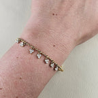 Fijne gouden armband met meerdere kleine hartjes gedragen om de pols