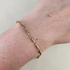Minimalistische gouden dames armband met kleine ronde kralen om de pols