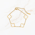 Goudkleurige dames armband met witte klaver details en verstelbare sluiting