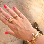 Goudkleurige ringen met geboortesteen, initialen, bloemen en parels met een set vrolijke armbanden