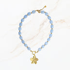 Licht blauwe kralen ketting met goudkleurige bedel