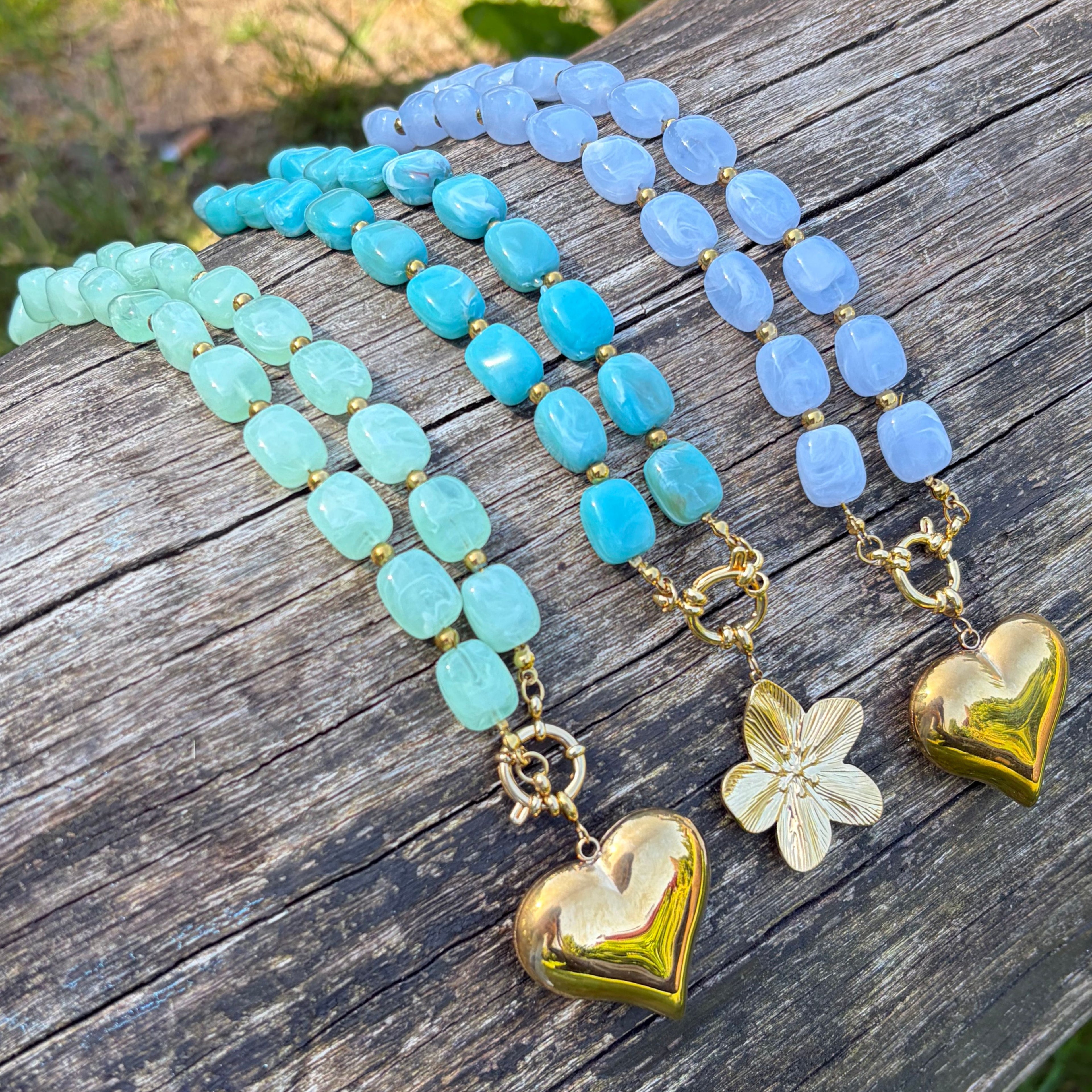 Turquoise blauwe kralen ketting met goudkleurige bedel
