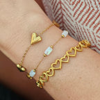 Subtiele gouden armband met witte details gecombineerd met meerdere dames armbanden