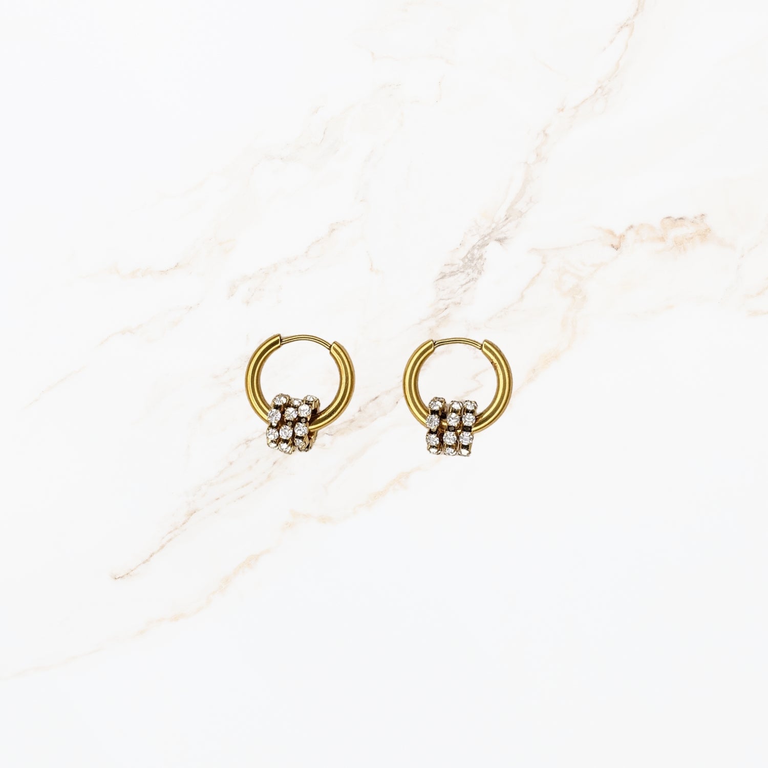 Seyso goudkleurige stainless steel hoop oorbellen met knoopdetail en kleine sprankelende steentjes in elegant en verfijnd design.