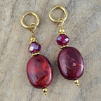 Bordeaux rode hangoorbellen met ovale kralen, fonkelende paarse kristallen en goudkleurige oorhaken. Stijlvolle herfst sieraden van Seyso.