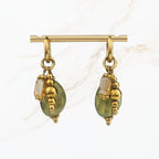 Elegante saliegroene hangoorbellen met ovale glaskralen, goudkleurige sierdetails en kleine transparante kralen. Handgemaakte dames sieraden van Seyso.
