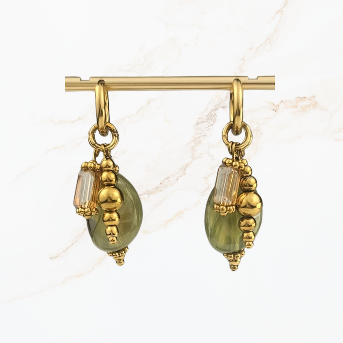 Elegante saliegroene hangoorbellen met ovale glaskralen, goudkleurige sierdetails en kleine transparante kralen. Handgemaakte dames sieraden van Seyso.