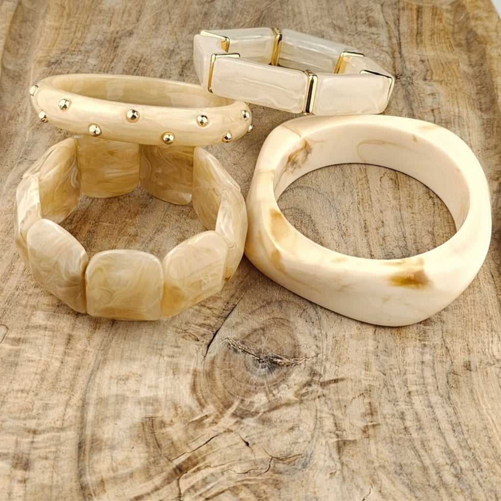 Grove crème dames armband met gouden studs gecombineerd met een fijn armbandje