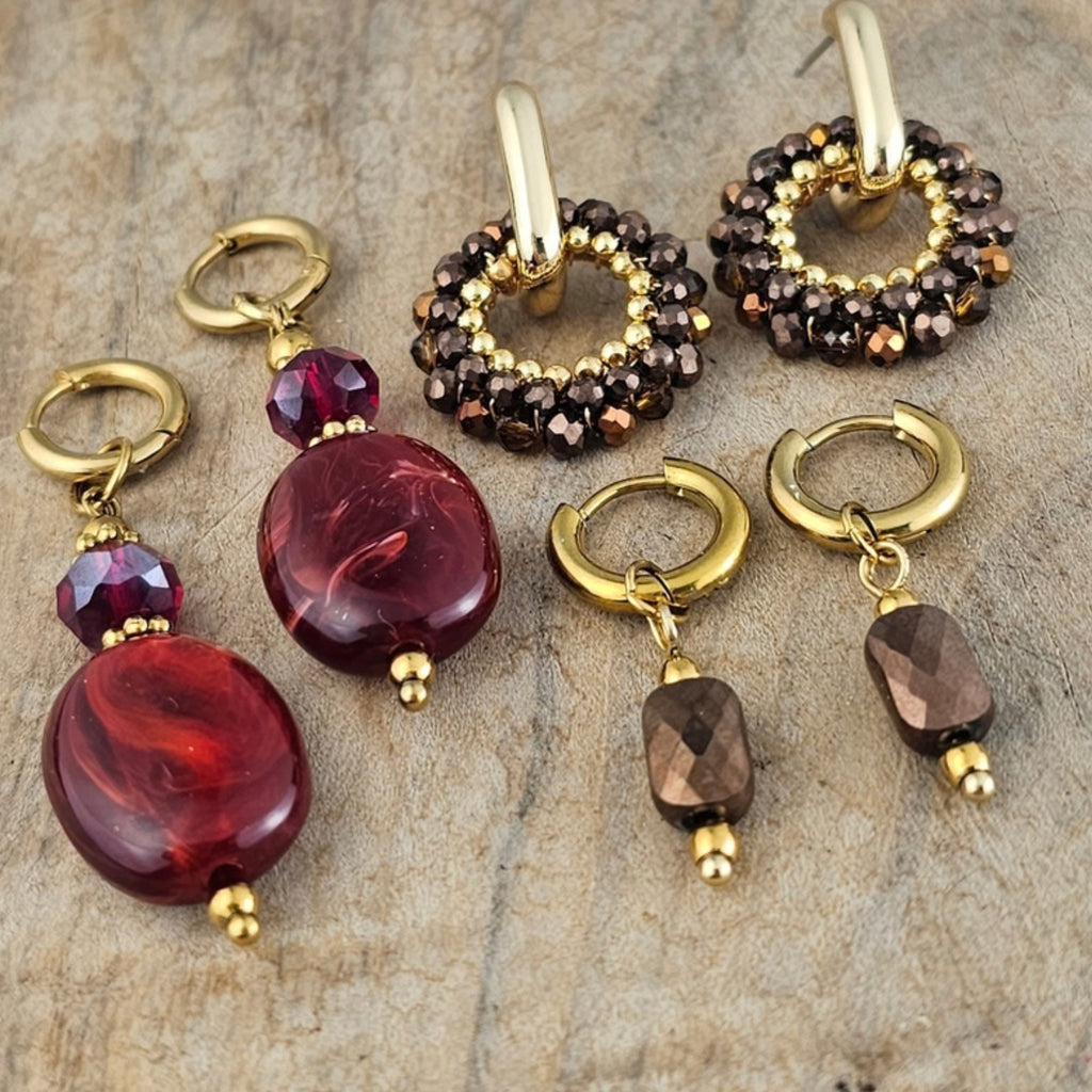 Verschillende oorbellen met bruine facetkralen, bordeaux rode hangers en goudkleurige details. Stijlvolle herfst en winter sieraden van Seyso.
SEO paginatitel