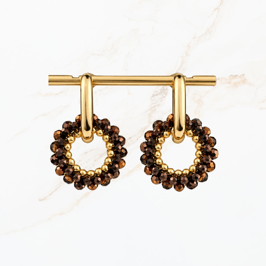 Bruine ronde oorbellen met fonkelende bronskleurige facetkralen, goudkleurige ringen en open cirkelvormige hangers. Elegante dames sieraden van Seyso.