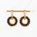 Bruine ronde oorbellen met fonkelende bronskleurige facetkralen, goudkleurige ringen en open cirkelvormige hangers. Elegante dames sieraden van Seyso.