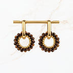 Bruine ronde oorbellen met fonkelende bronskleurige facetkralen, goudkleurige ringen en open cirkelvormige hangers. Elegante dames sieraden van Seyso.