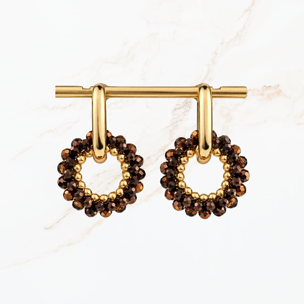 Bruine ronde oorbellen met fonkelende bronskleurige facetkralen, goudkleurige ringen en open cirkelvormige hangers. Elegante dames sieraden van Seyso.