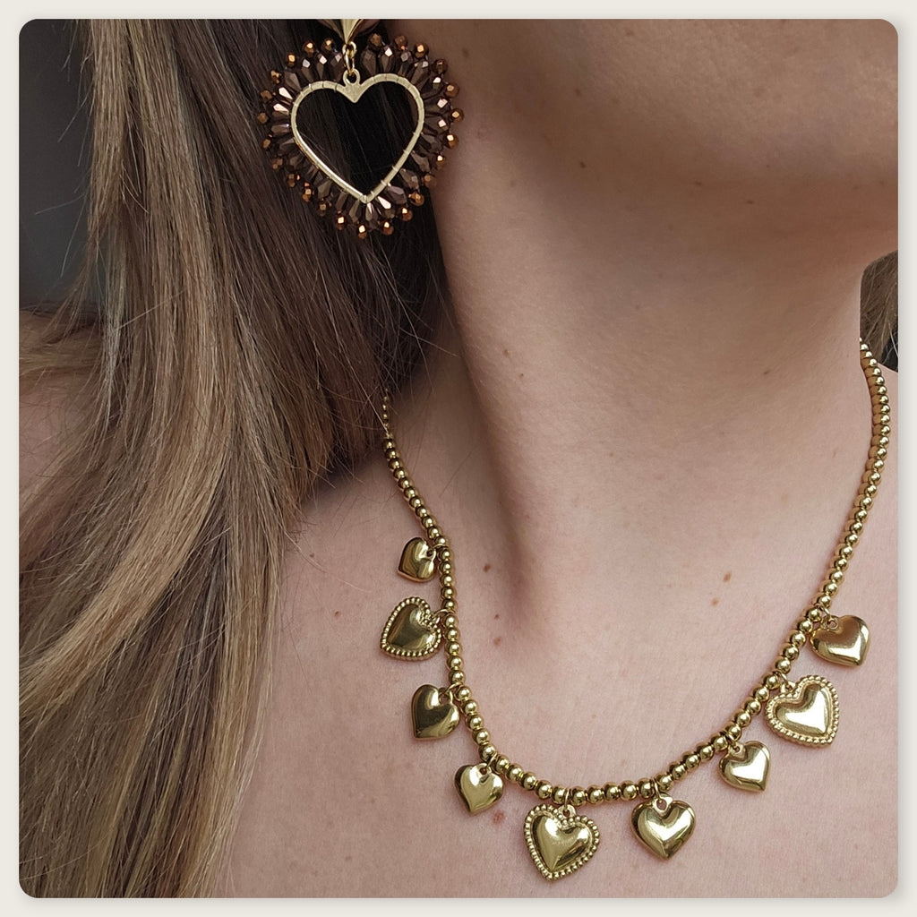 Goudkleurige stainless steel kralenketting met meerdere kleine hartbedels